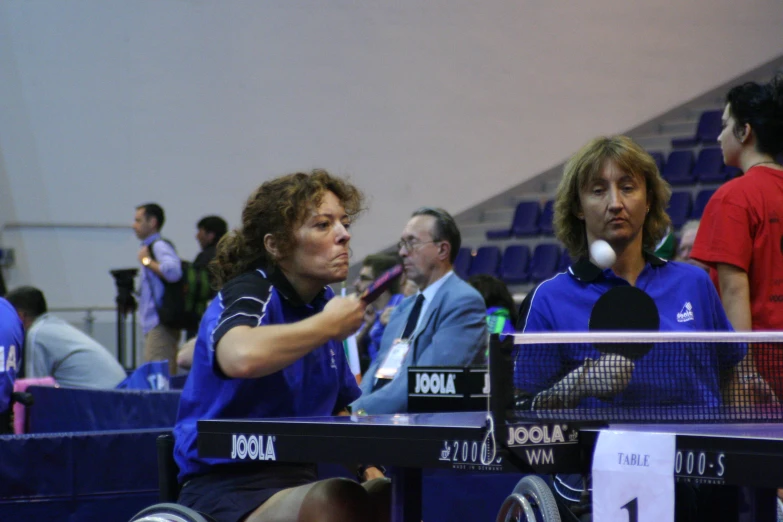 a woman swings her tennis racket with an opponent