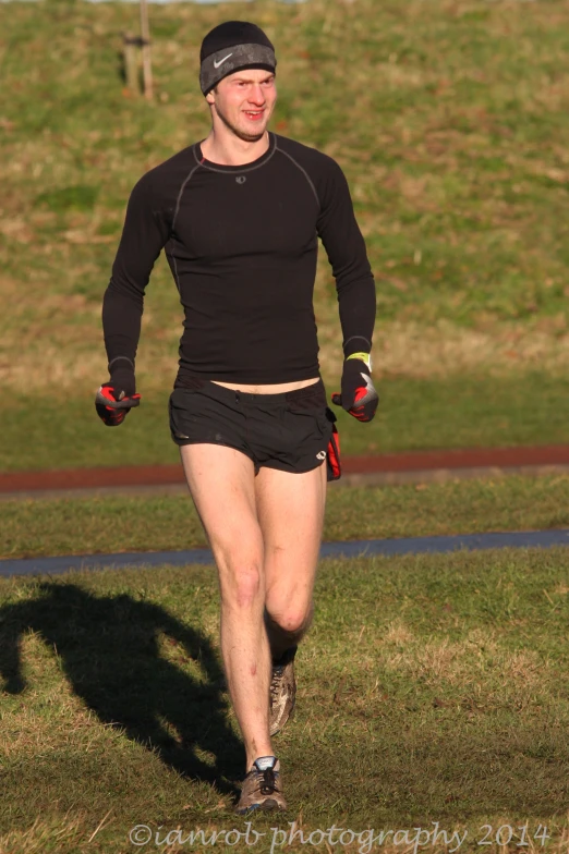 a man running while wearing shorts and a hat