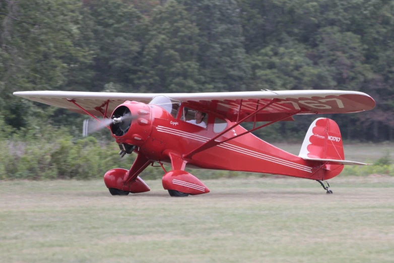 a red airplane is parked on the grass