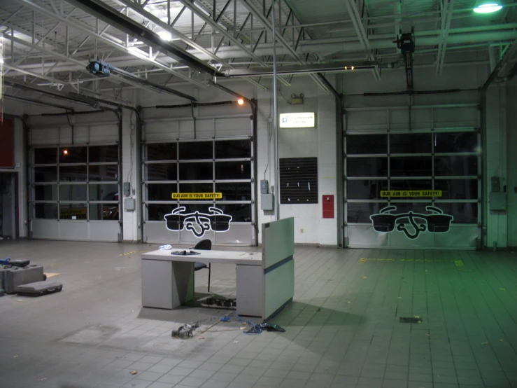 an empty garage with graffiti written in black on the windows