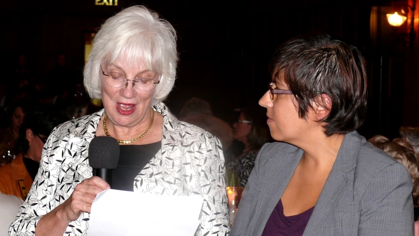 two women standing next to each other on a stage