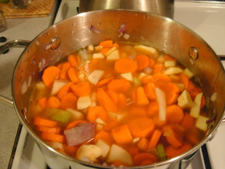 a pot that is filled with carrots and onions