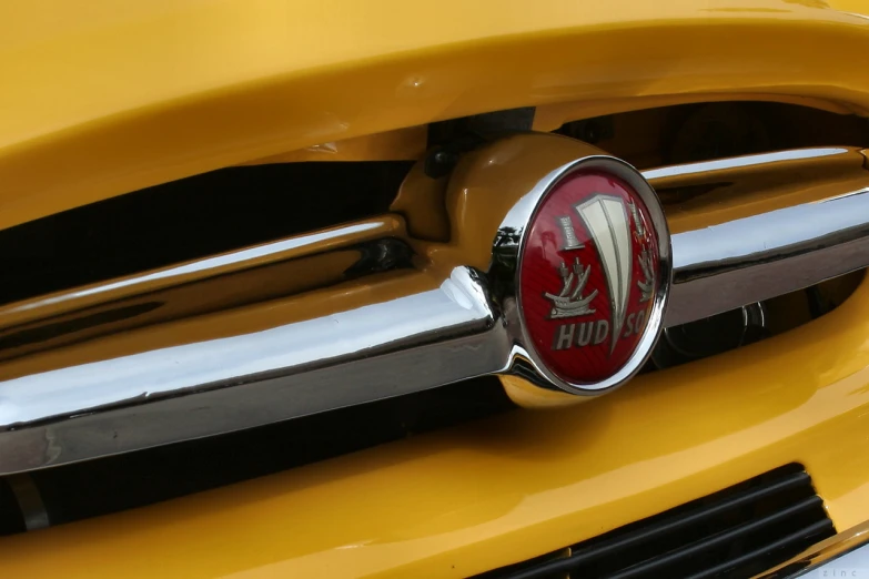 a close up of the emblem on a shiny yellow car