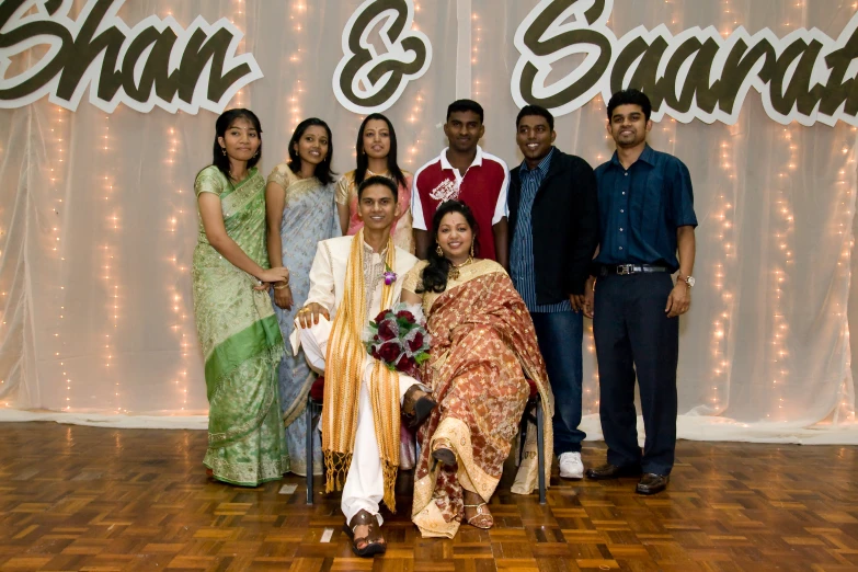 an indian family posing for a picture on a stage