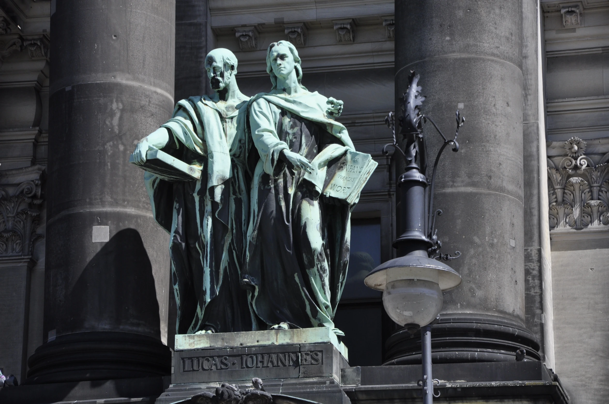 two statues sitting on the side of a building