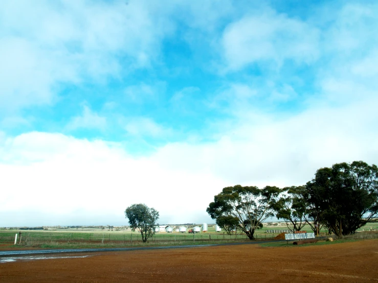 a large open field with trees and a bus on it