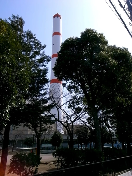 the light house is surrounded by trees and blue sky