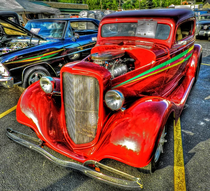 a classic automobile with colorful stripes parked in a parking lot