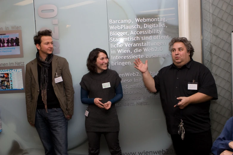 people standing next to a wall covered with information