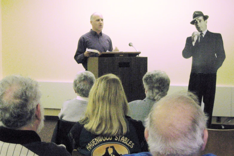 man in a black hat at podium giving a speech