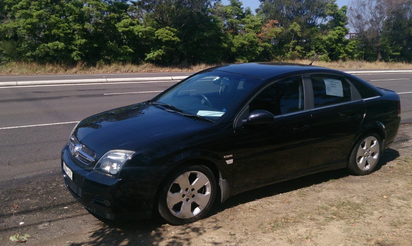 the black car is parked on the side of the road