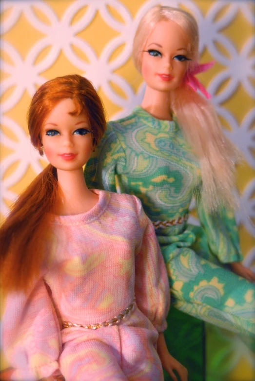 two barbie dolls sitting next to each other