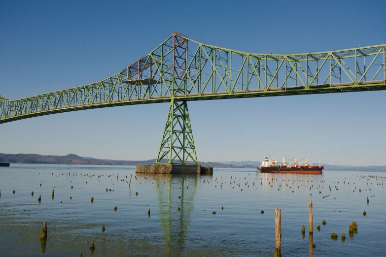 a bridge with water underneath and a ship under it