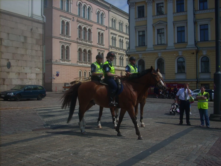 two mounted police officers walking down a city street