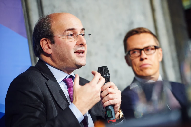 two men are sitting in front of a microphone