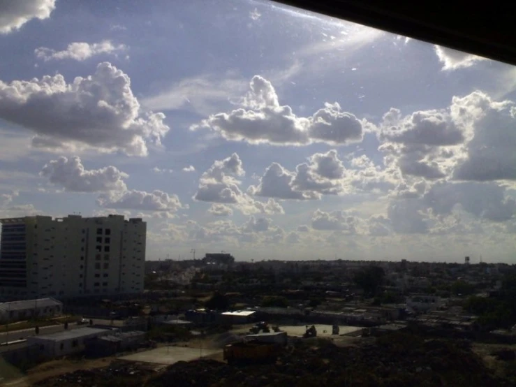 clouds in the sky above city buildings from a window