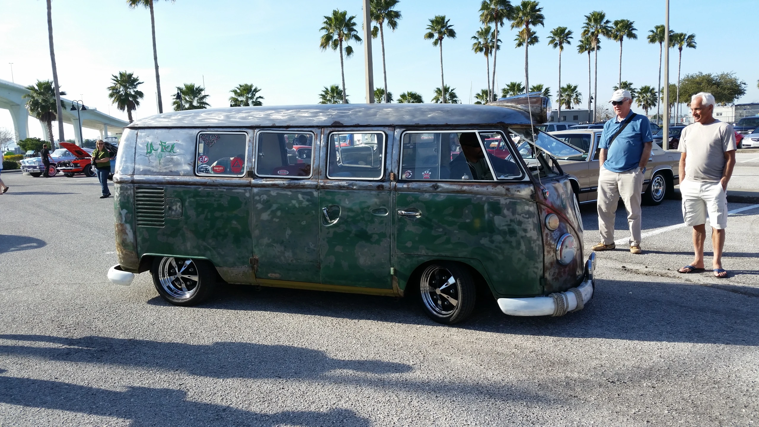 an old camper van in a parking lot with others around