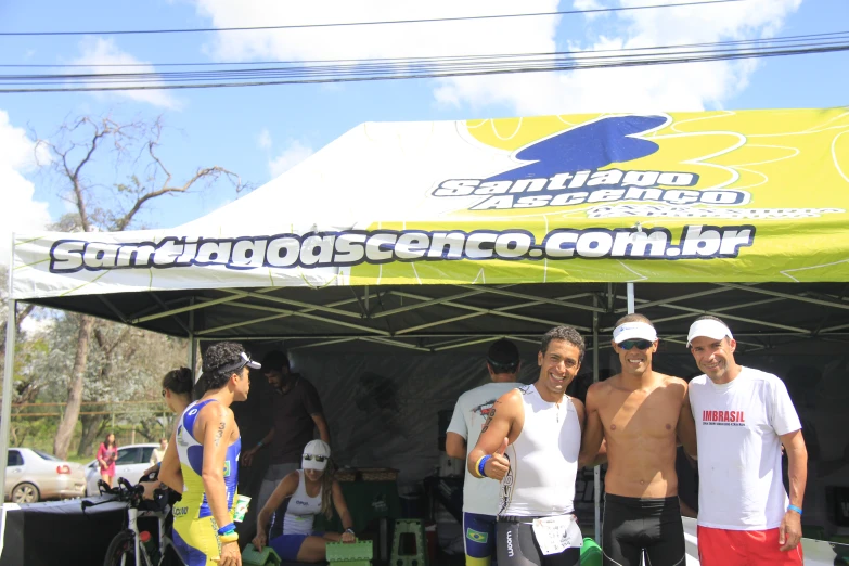 some men standing under a tent holding surfboards