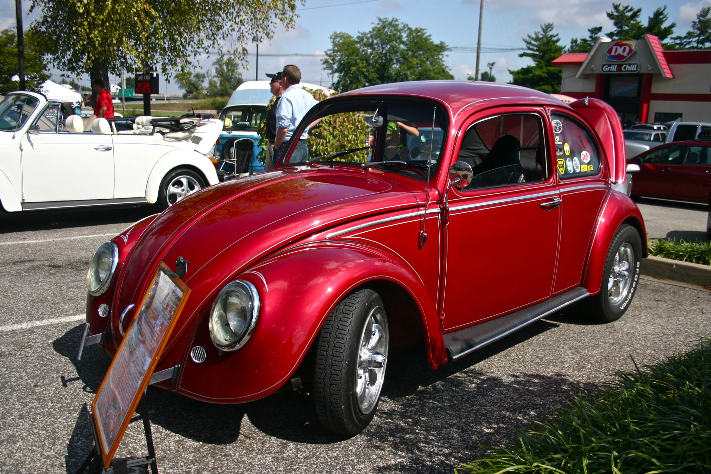 an old red car is parked on the road