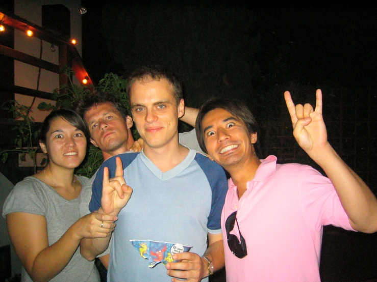 three guys are standing together and pointing to the camera