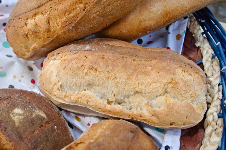 a close up of various types of bread in a basket