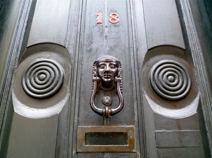 a door with a large carved face in the middle