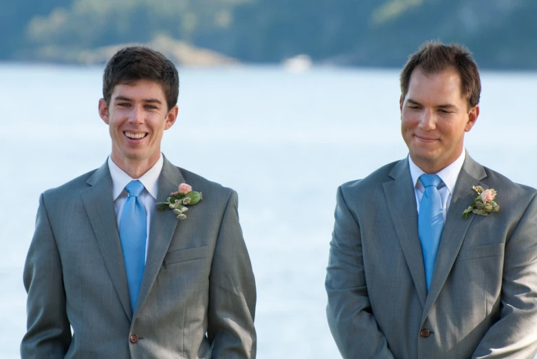 the two young men are dressed nicely and smiling