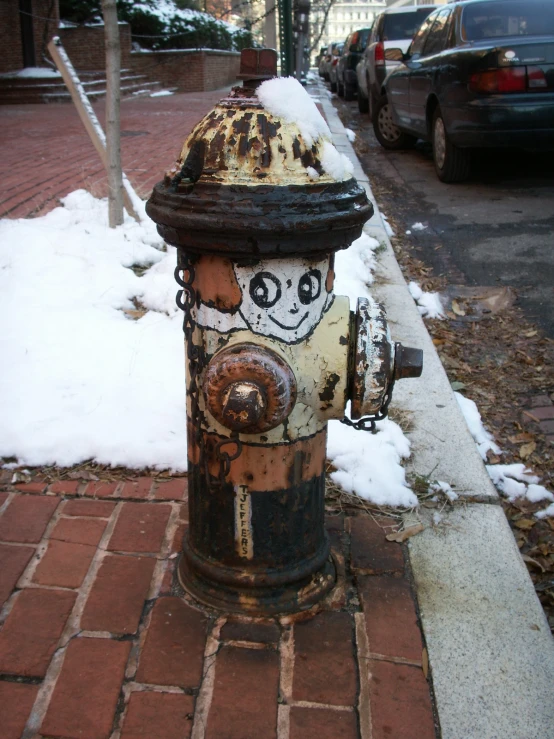 an antique fire hydrant on a city street with snow