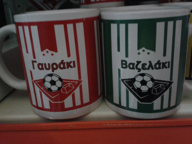 two coffee mugs depicting different teams used in the football world