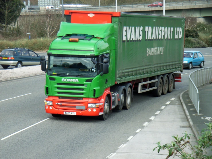 a semi truck on a road passing a bridge
