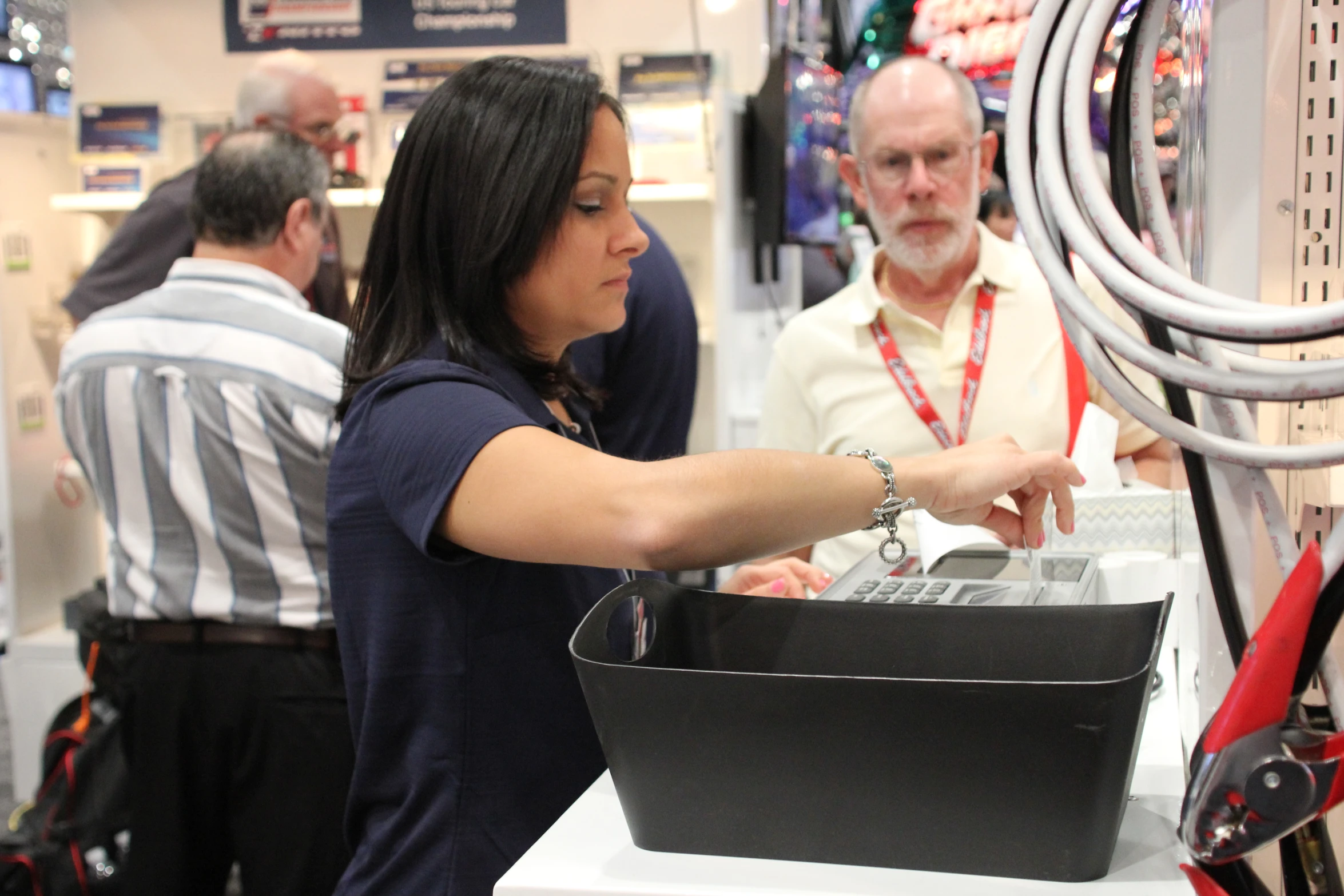 a lady checking out some electronic devices at a show