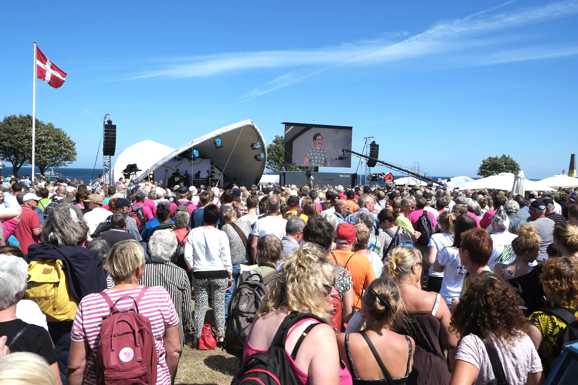 a group of people at an event under a blue sky