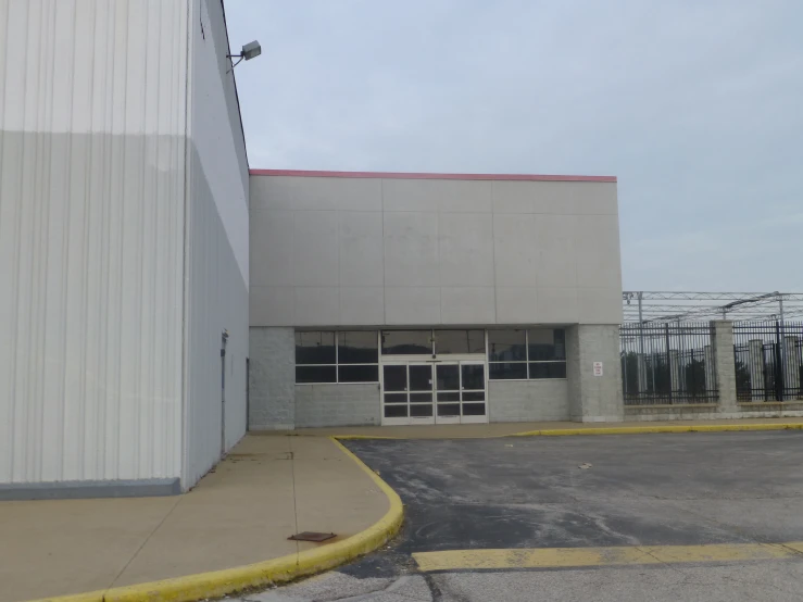 a parking lot next to a tall industrial building