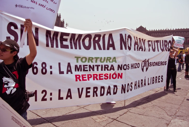 people holding up a large sign and posters