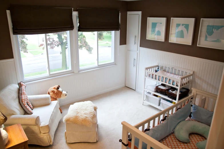 an infant's room with a crib, toys and artwork on the wall