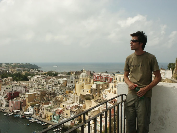 man on balcony with eyeglasses looking at town