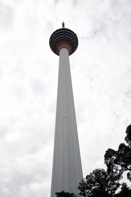 an airplane flying above a tall tower on the ground