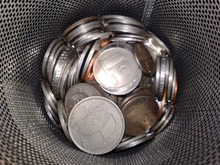 a small silver metal pot containing some coins