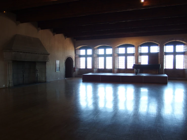 the large room has wood floors and windows