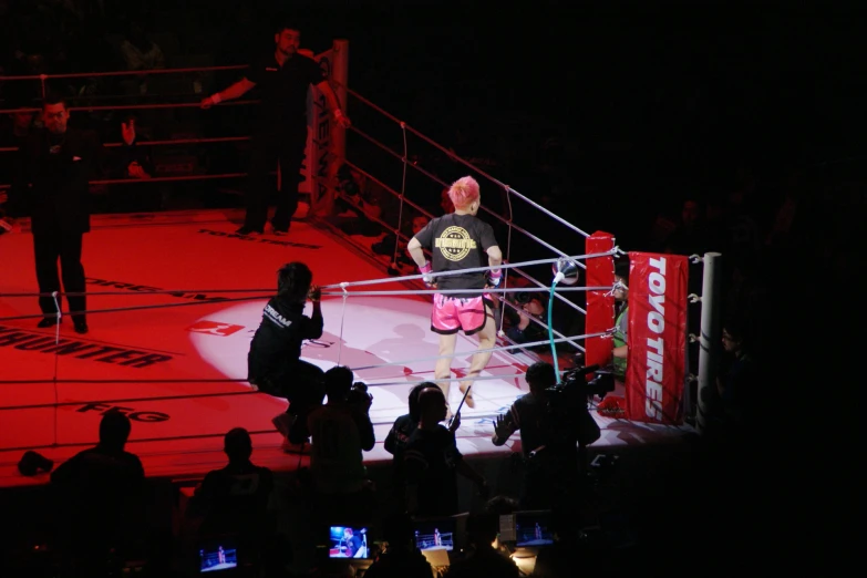 two men in the ring while another guy holds his hands behind him