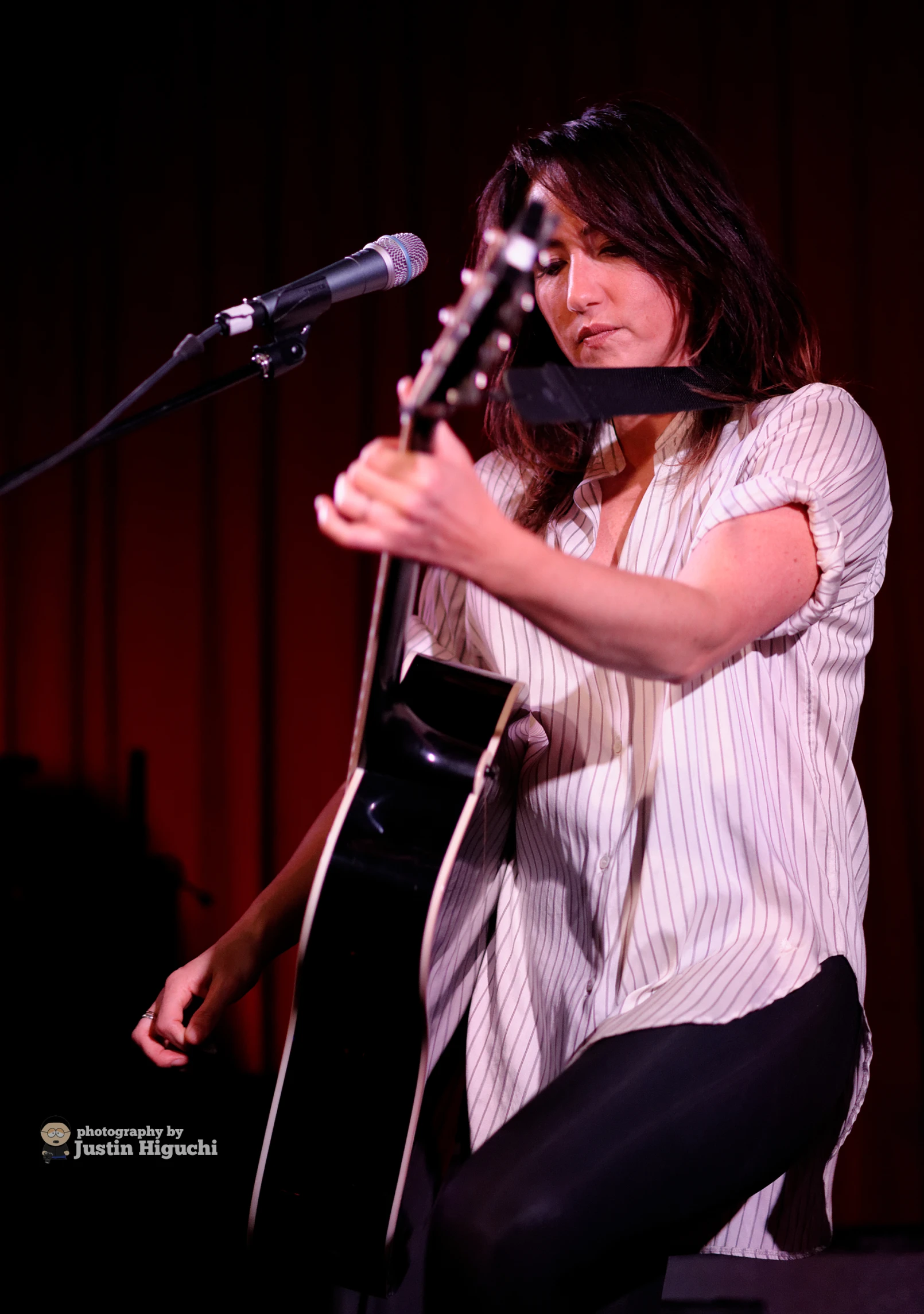 a woman with long hair is playing a guitar