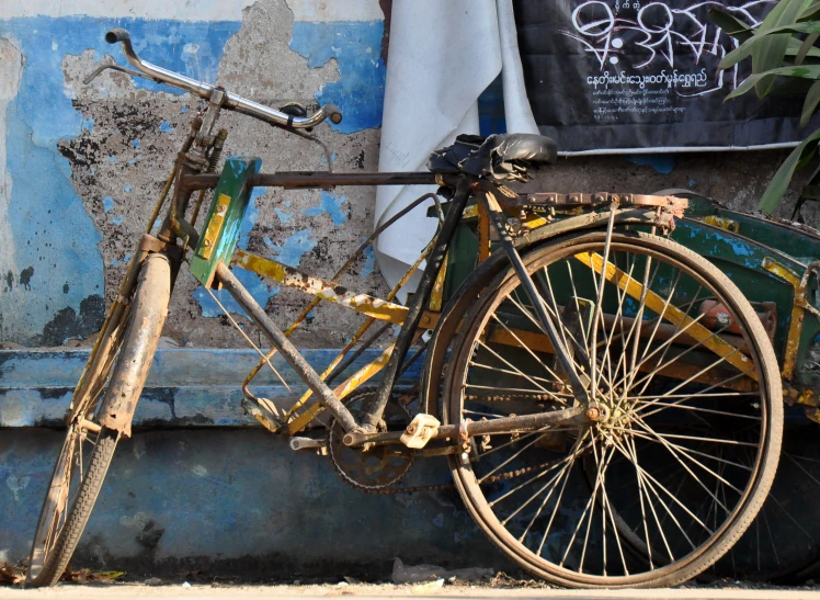 an old bicycle parked against a dirty wall