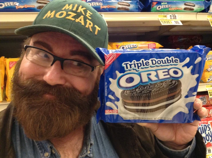 a man with a box of oreo and cap holding up a package