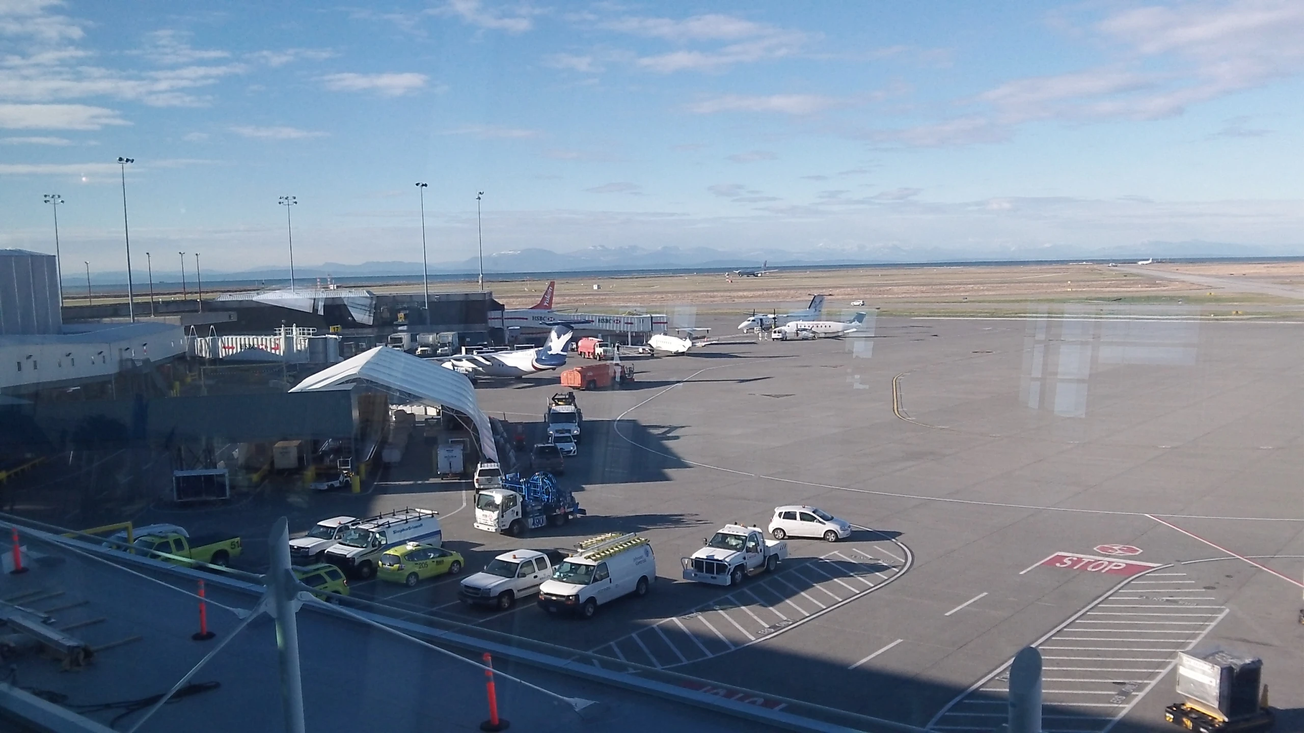 many planes on the runway outside the gate