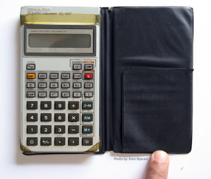 a hand holding a black leather wallet with a calculator