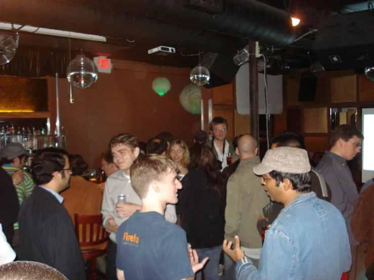 a crowd of people at a bar standing around