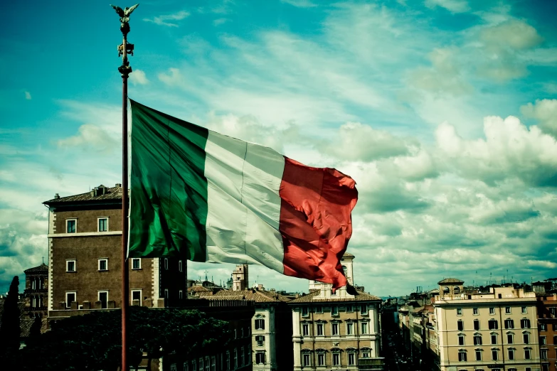 two different flags fly together on a partly cloudy day