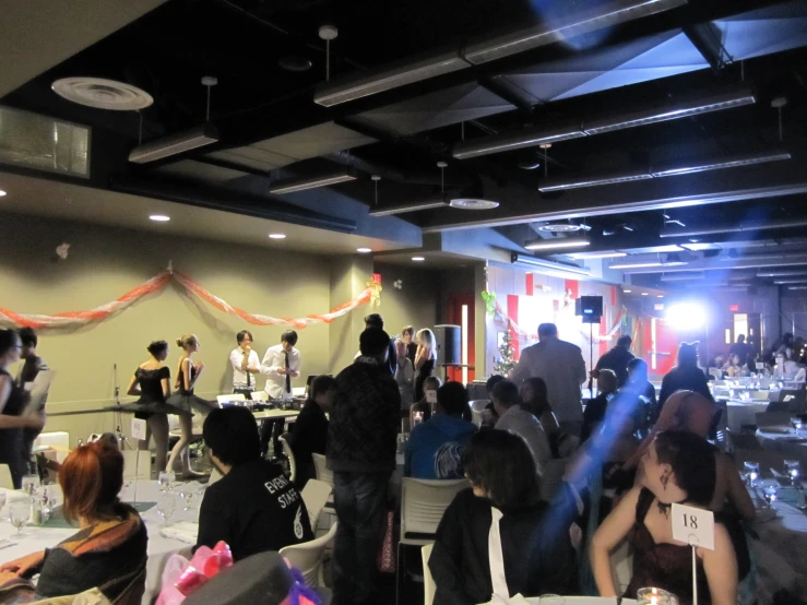 a room full of people sitting around with tables