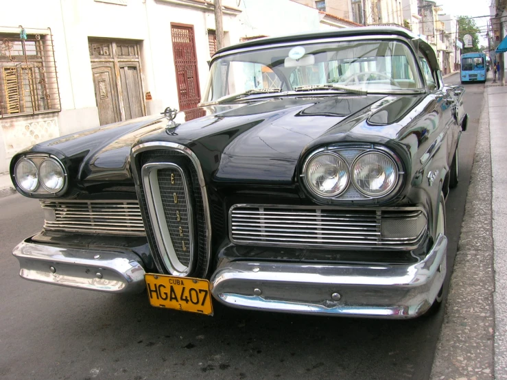 an old fashion black car parked on the side of the road