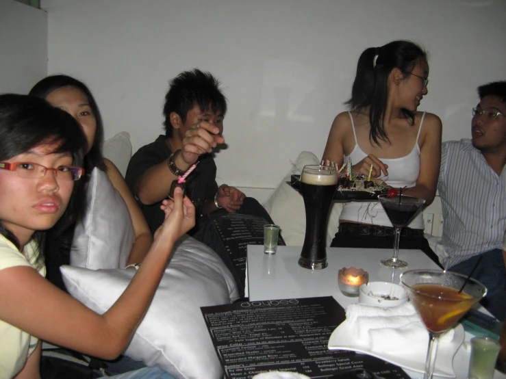 a group of young people sit around a table